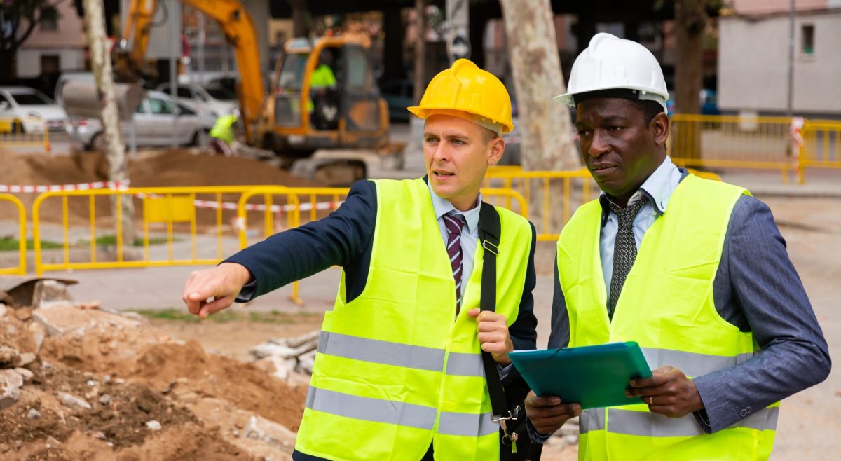 African-american,And,European,Men,Engineers,Discussing,Road,Repairing,Works.,One