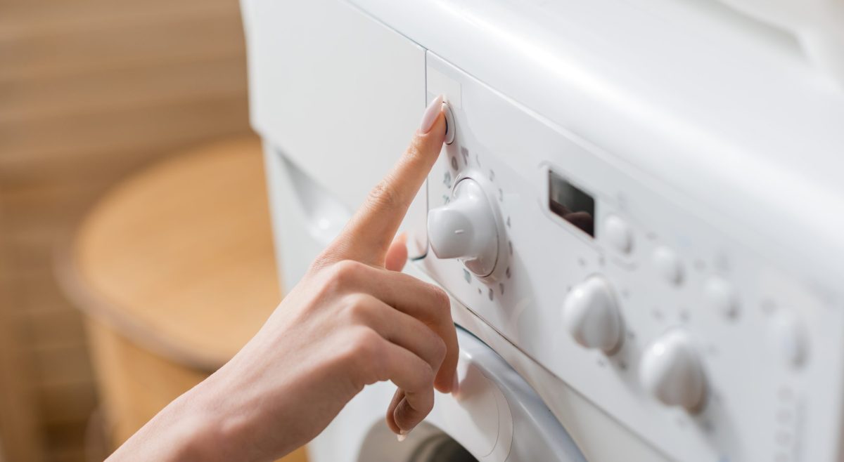Cropped,View,Of,Woman,Pushing,Button,Of,Washing,Machine,In